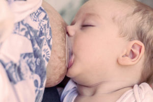 Vauva juo maitoa rinnalta, rinnassa rintakumi.