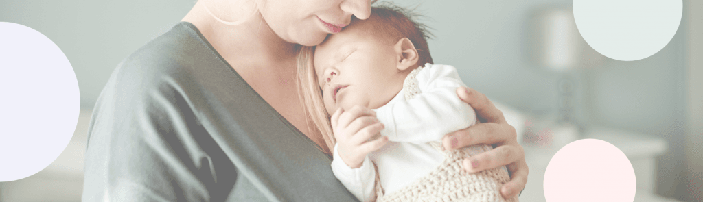 Äiti pitelee sylissä pientä vauvaa, lähellä kasvojaan.