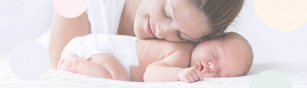 Pieni vauva pötköttää vaippasilteen, äiti pitää päätä hellästi vauvan selän päällä.