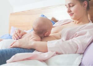 Nainen pitää vastasyntynyttä vauvaa ihokontaktissa