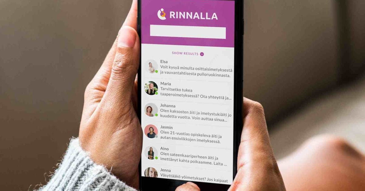 Henkilöllä on kädessä älypuhelin, jossa on auki Rinnalla-sovellus