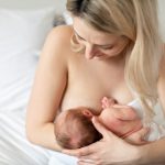 Vanhempi imettää pientä vastasyntynyttä istuen